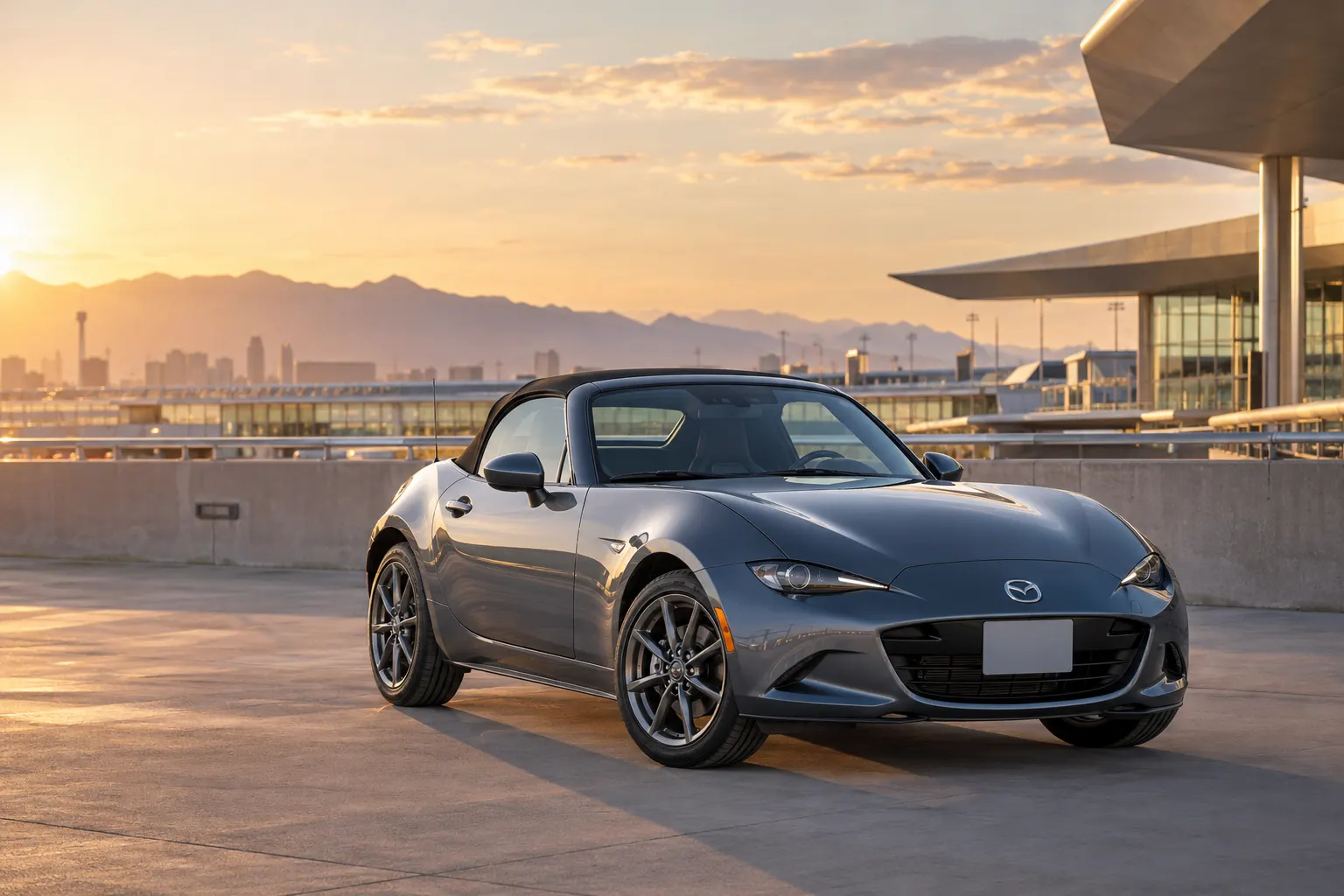 Gray 2026–2027 Mazda MX-5 Miata Convertible at an airport terminal at golden hour