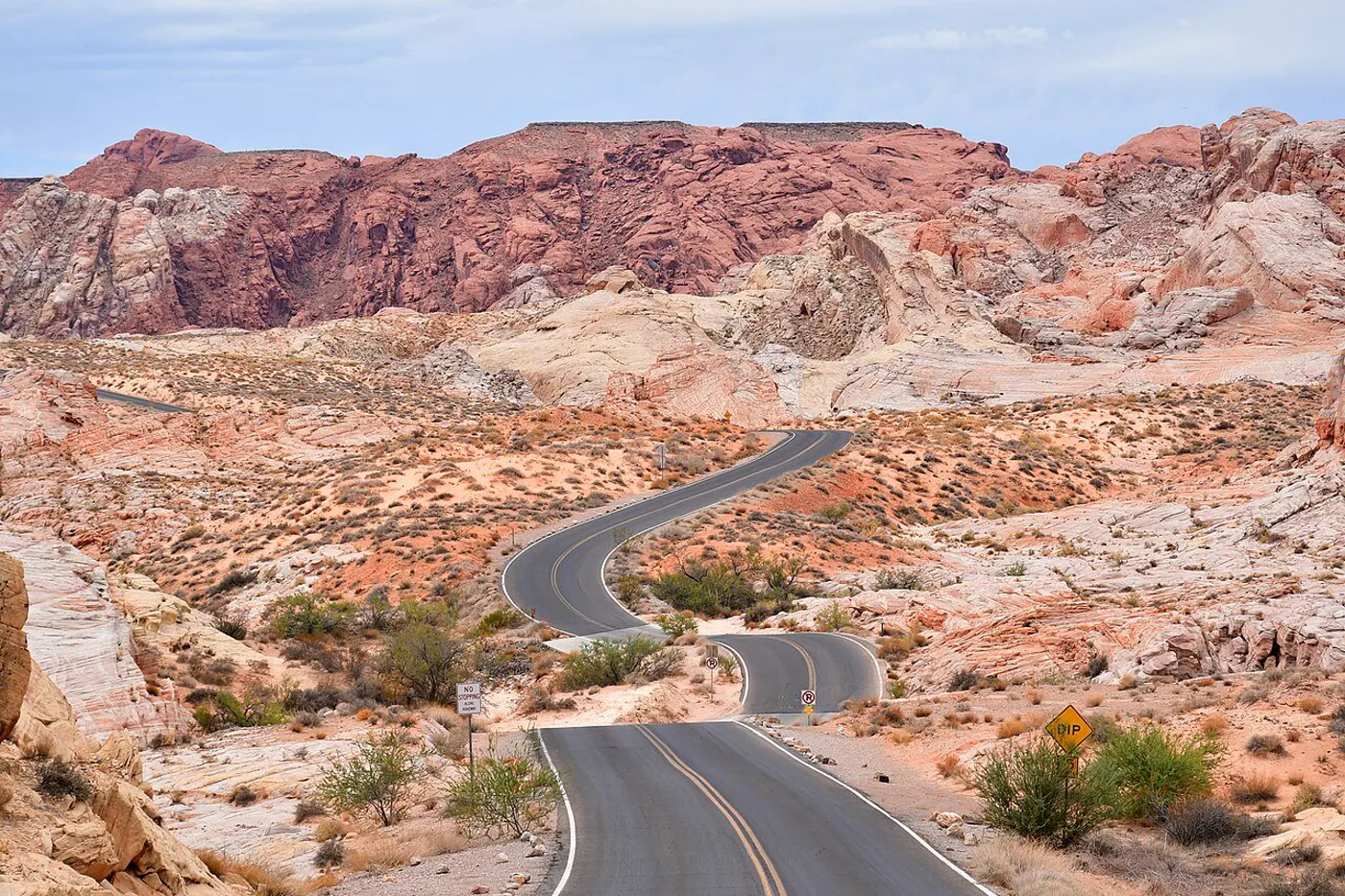 Sunlit desert road winding through Valley of Fire State Park